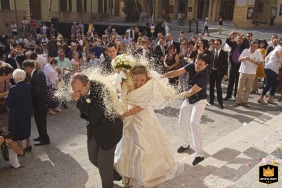 Wedding guests in Brisighella, Italy, toss rice at the bride and groom after their wedding ceremony.